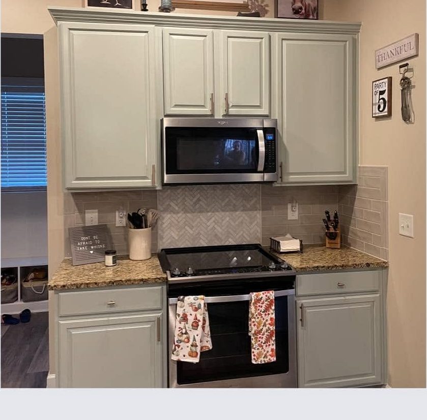 The same kitchen cabinets refinished in a soft sage by Carolina Superior Painting