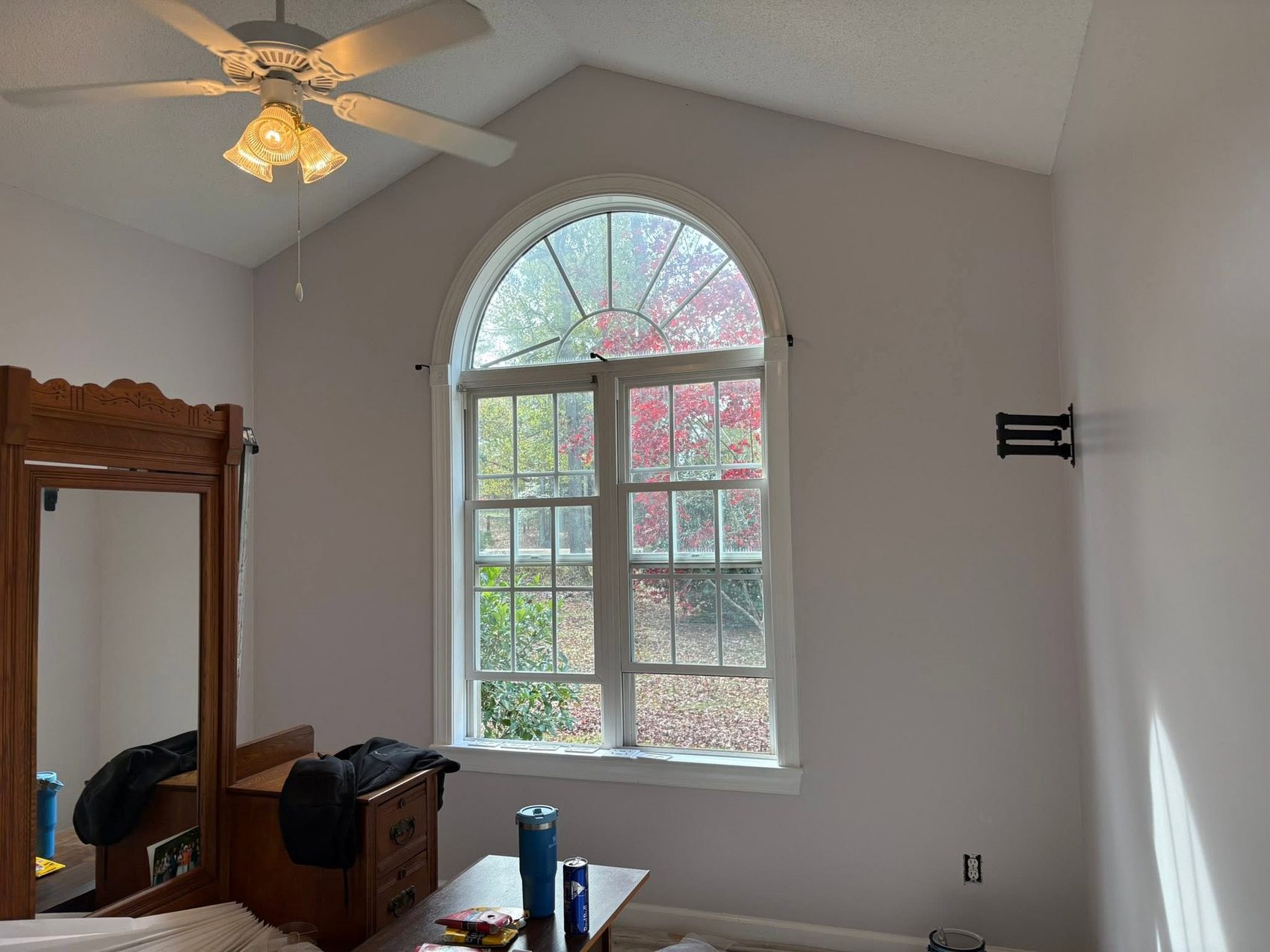 A bedroom with an arched window by Carolina Superior Painting LLC