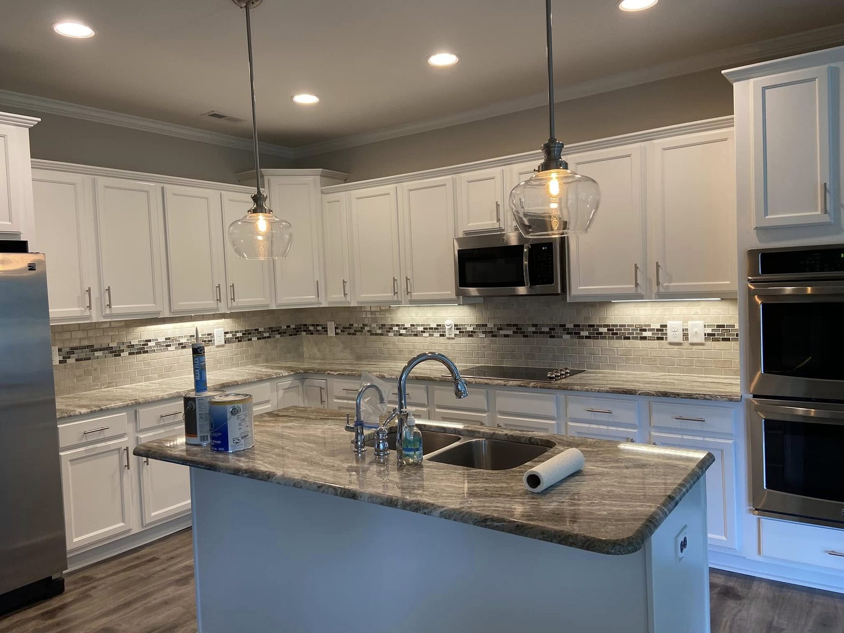 Island and uppers in white, granite kept by Carolina Superior Painting LLC