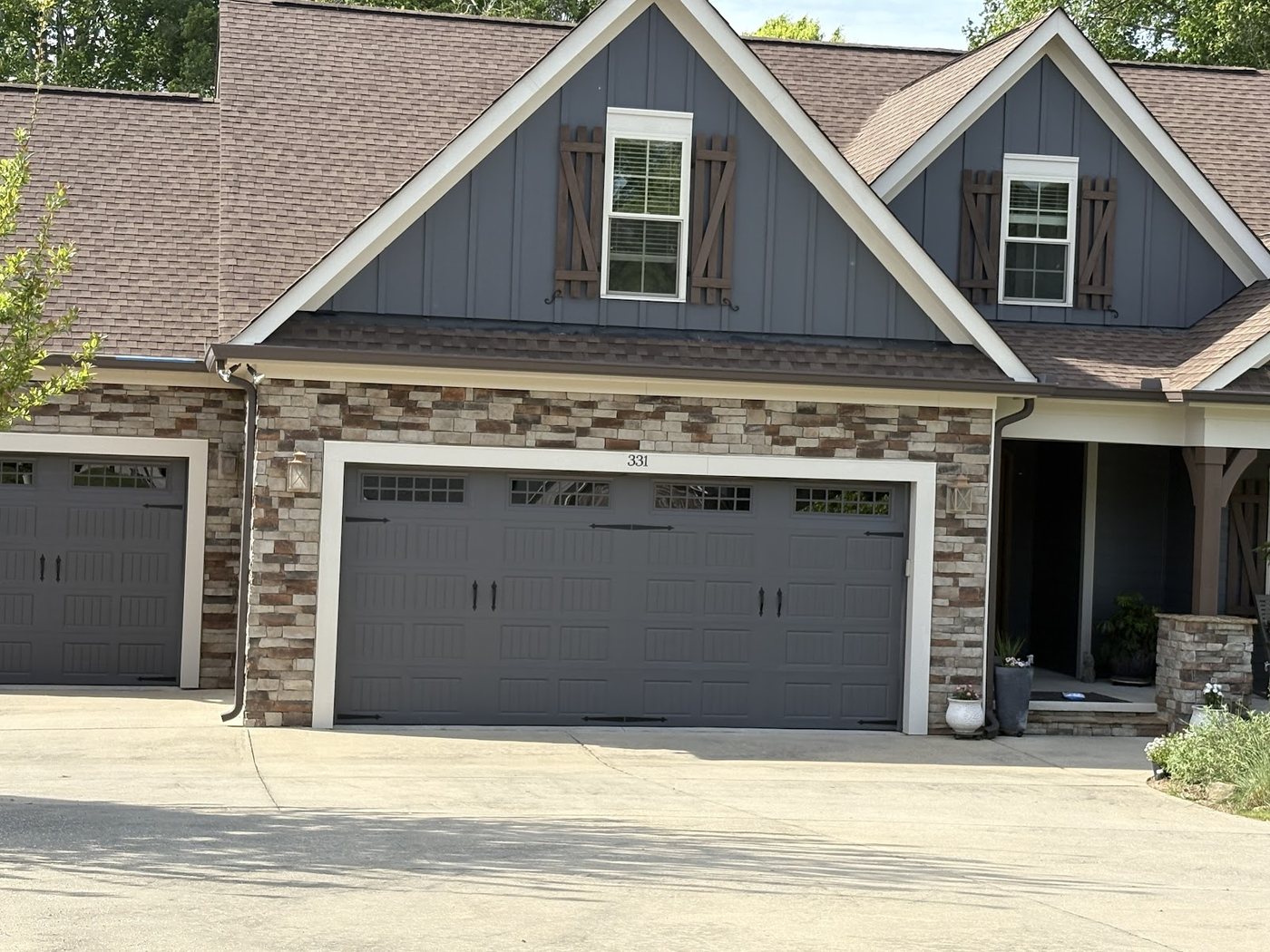 Board and batten and garage doors in deep navy by Carolina Superior Painting LLC