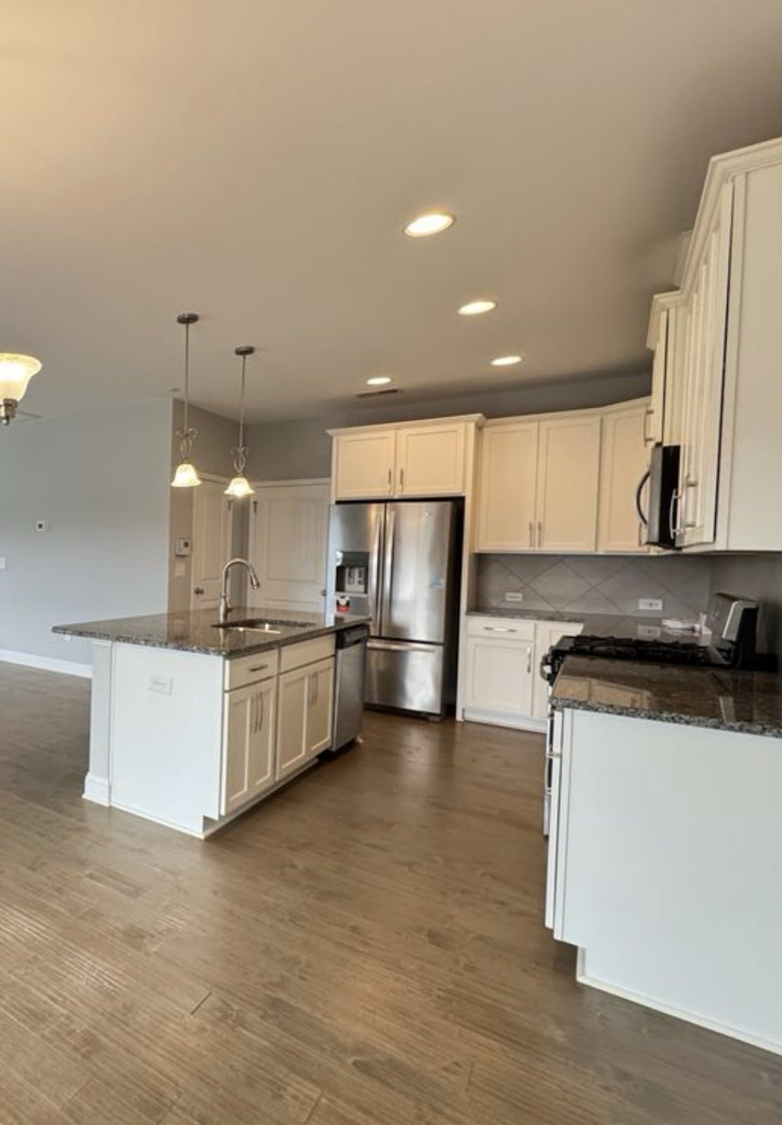 A bright white kitchen, island and trim finished even by Carolina Superior Painting LLC