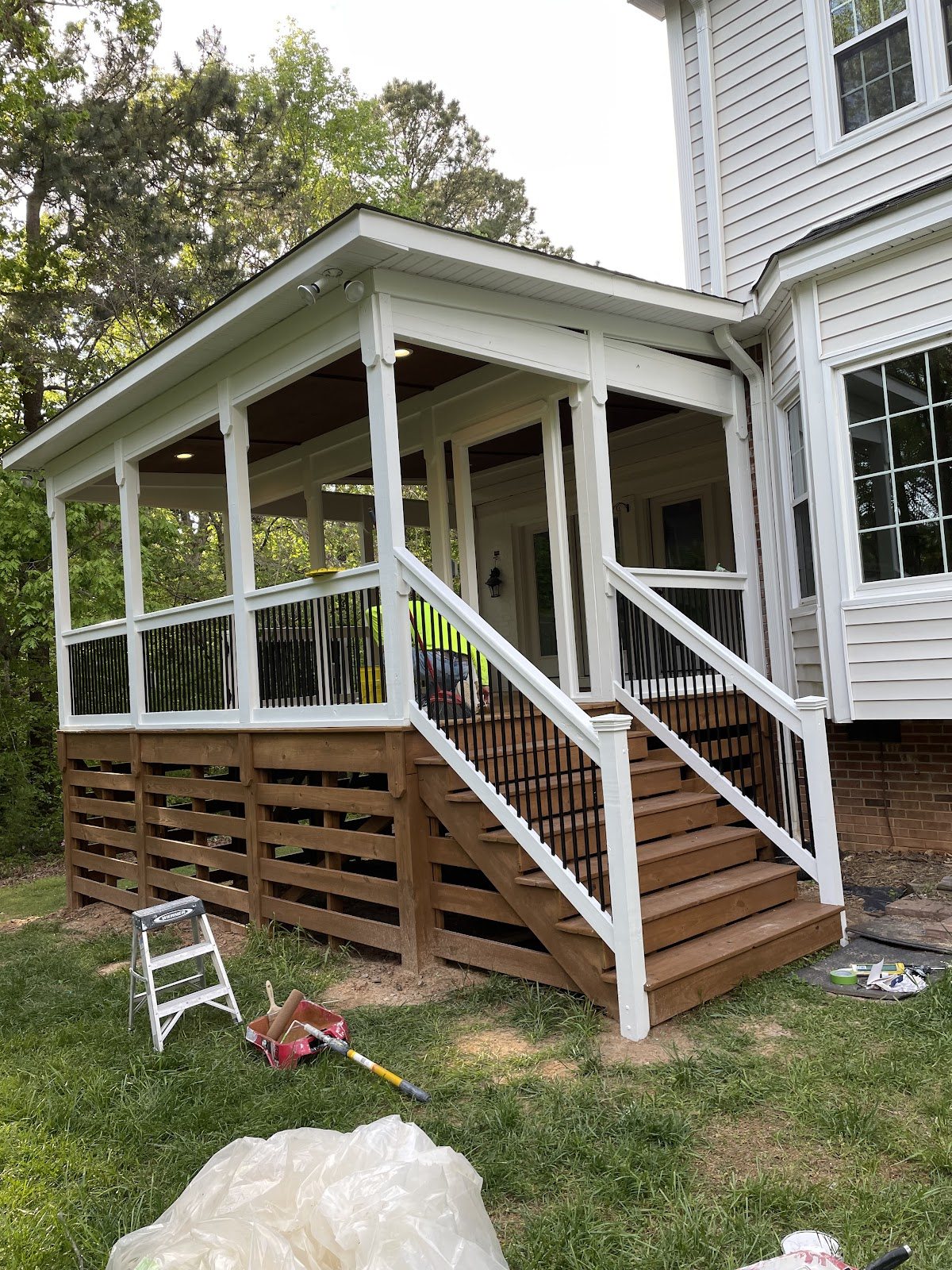 A screened porch and deck rail finished in white by Carolina Superior Painting LLC